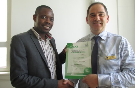 Hospital Manager David Colyer presents Sandford Ward Manager Joseph Muguti with Sandford's AIMS certificate