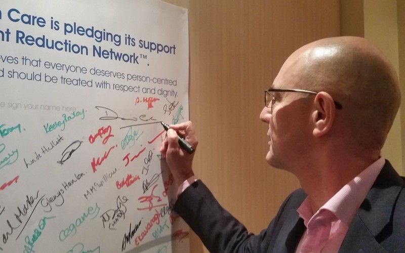 Chief Executive David Cole signing his support for reducing restrictive practice