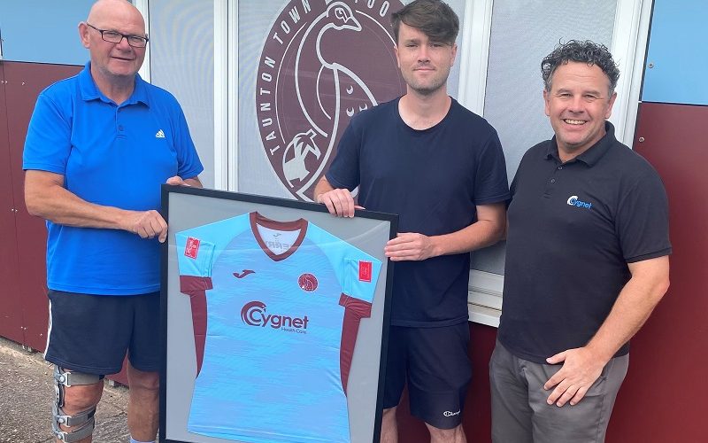Kevin Sturmey, Taunton Town FC Chairmen presents a framed shirt to a service user from Cygnet Hospital Taunton and active life lead Stu Hooper