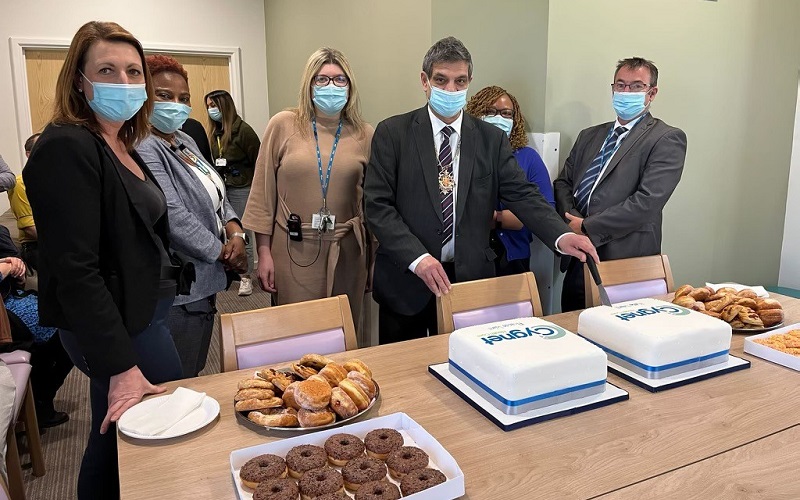 Cllr Saj Hussain cutting the cake at the opening of Kahlo Ward with members of the Cygnet Hospital Woking team