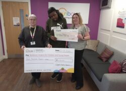 Hayley and a resident from Birches presenting the cheque to Rainbows Hospice