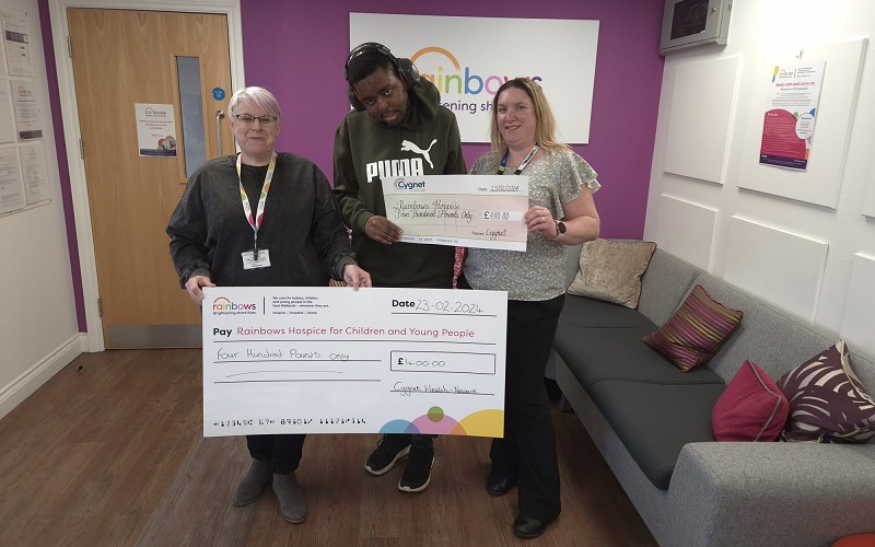 Hayley and a resident from Birches presenting the cheque to Rainbows Hospice