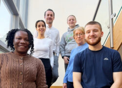 A group of staff standing together on a staircase inside Beacon House, marking the service’s achievement of a ‘Good’ CQC rating.
