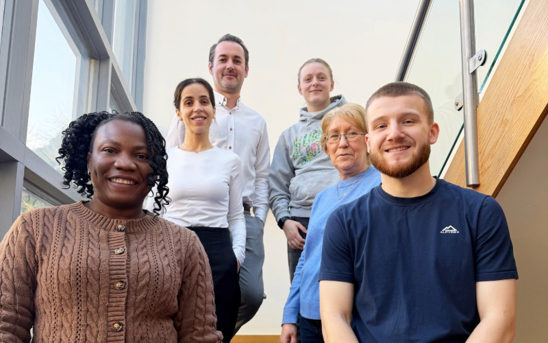 A group of staff standing together on a staircase inside Beacon House, marking the service’s achievement of a ‘Good’ CQC rating.