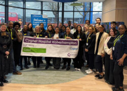 A group of healthcare staff standing together indoors at Cygnet Hospital Wolverhampton, holding a banner that reads “Cygnet Hospital Wolverhampton – CQC rating: Good,” celebrating the hospital’s inspection outcome.