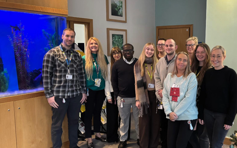 A group of staff standing together inside Cygnet Oaks mental health hospital in Barnsley, marking the service’s achievement of the Carers Trust Triangle of Care accreditation. The team are pictured in a welcoming communal area.