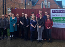 Staff stand together outside St William’s Independent Hospital, posing beside a banner announcing a CQC rating of Overall Good with Outstanding in Well Led from December 2025.