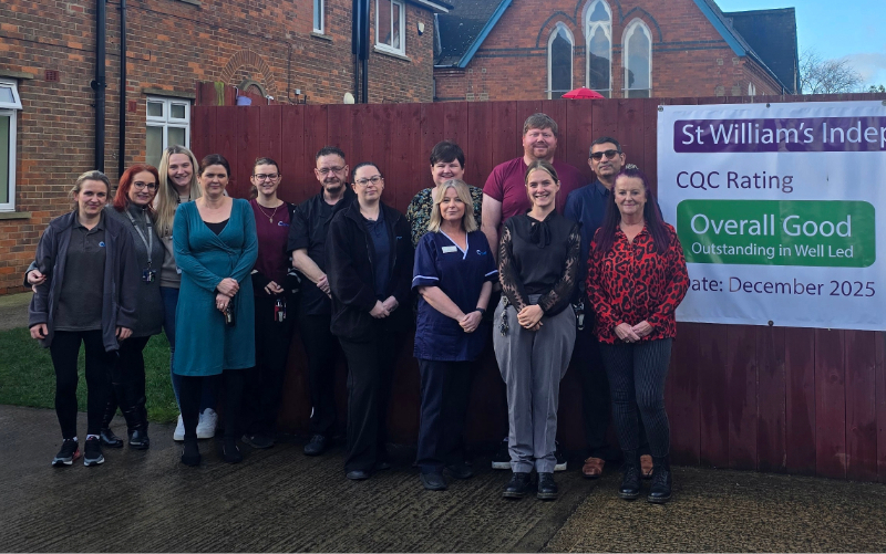 Staff stand together outside St William’s Independent Hospital, posing beside a banner announcing a CQC rating of Overall Good with Outstanding in Well Led from December 2025.