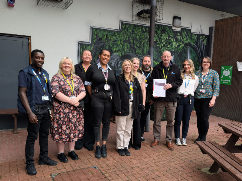 Cygnet Hospital Derby team smiling outside, with the manager holding the 'Good' CQC report.