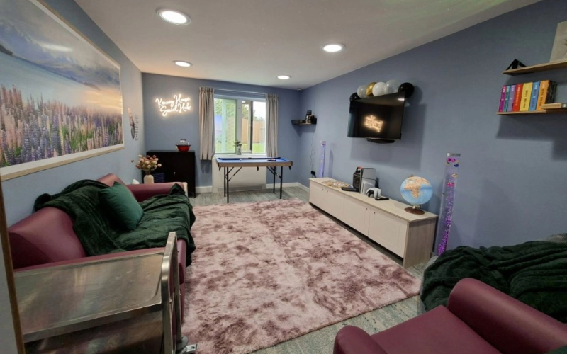 Modern social hub with sofas, games, TV and soft lighting at Cygnet Kenney House.