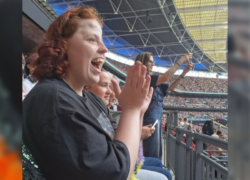 A supported individual clapping in the crowd at the Harry Styles concert at Wembley