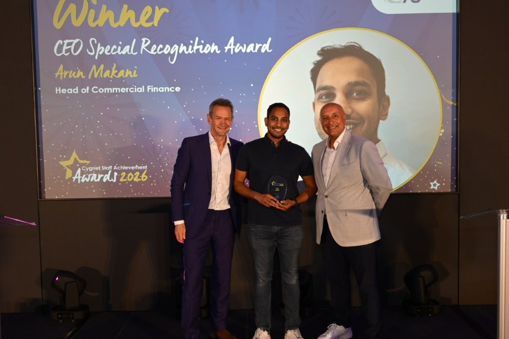 The winner of the Special Recognition Award on stage with CEO Tony Romero and celebrity host Alexander Armstrong