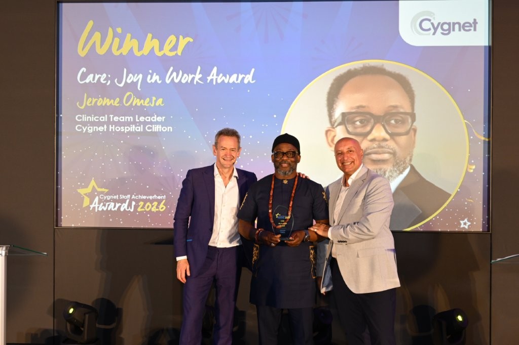 The winner of the Care; Joy in Work Award on stage with CEO Tony Romero and celebrity host Alexander Armstrong