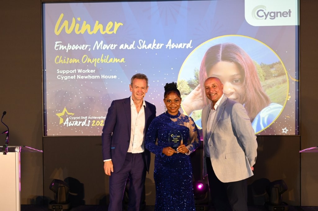 The winner of the Empower; Mover and Shaker Award on stage with CEO Tony Romero and celebrity host Alexander Armstrong