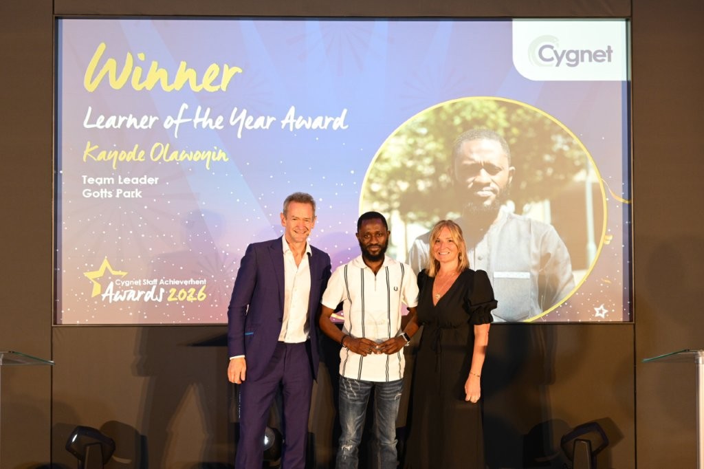 The winner of the Learner of the Year Award on stage with Head of HR Jenny Gibson and celebrity host Alexander Armstrong