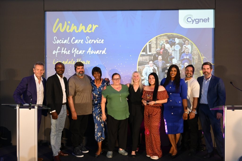 The winners of the Social Care Service of the Year on stage with CEO of Social Care Gareth Williams and celebrity host Alexander Armstrong