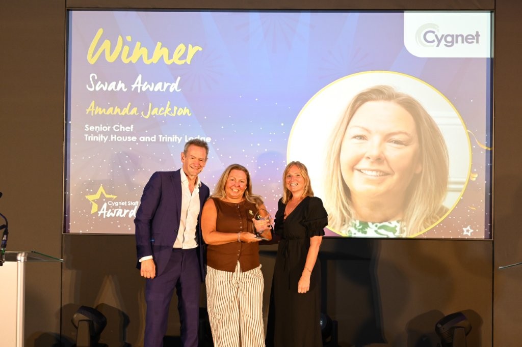 The winner of the Swan Award on stage with Head of HR Jenny Gibson and celebrity host Alexander Armstrong