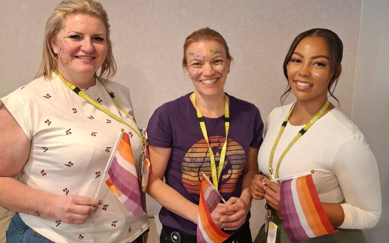 Members of the team at Cygnet Elowen Hospital after the glitter contest holding the orange, white, and purple Lesbian Pride Flag