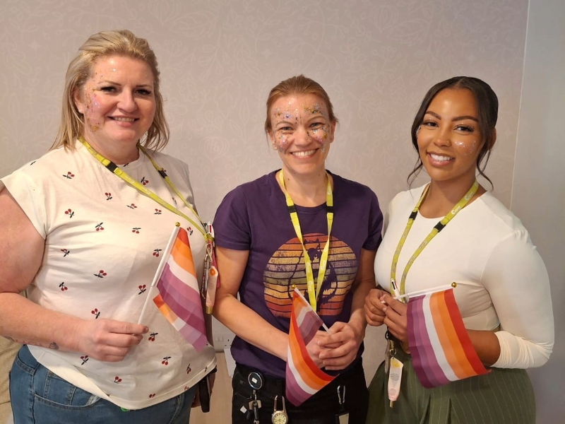 Members of the team at Cygnet Elowen Hospital after the glitter contest holding the orange, white, and purple Lesbian Pride Flag