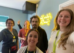 The team and a service user smiling in the newly opened social hub