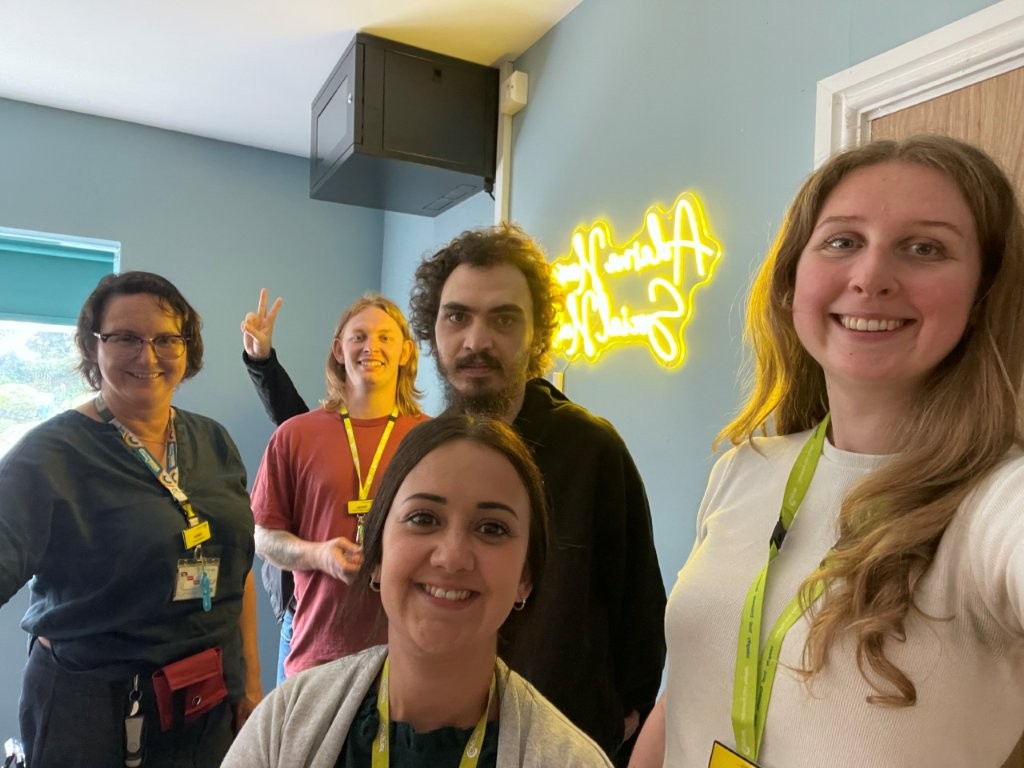 The team and a service user smiling in the newly opened social hub
