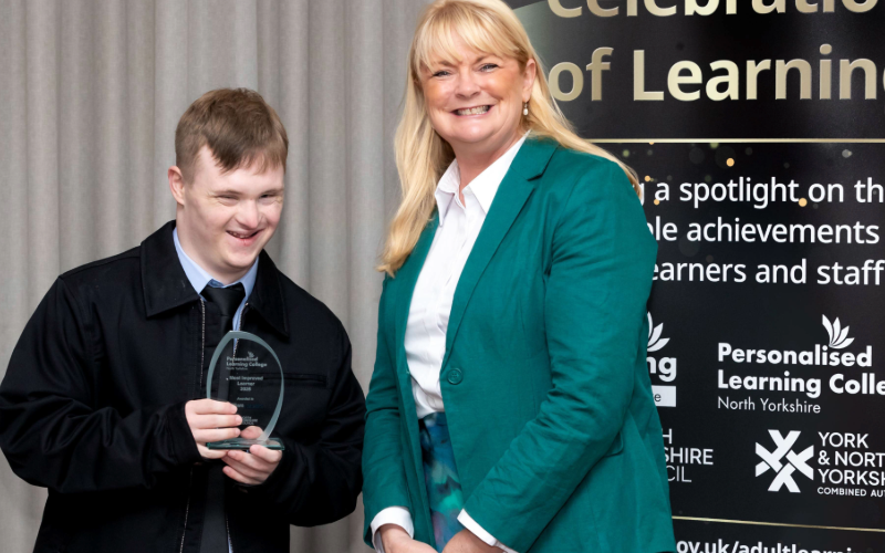 Hope House resident William posing at the awards with a member of the college team on stage