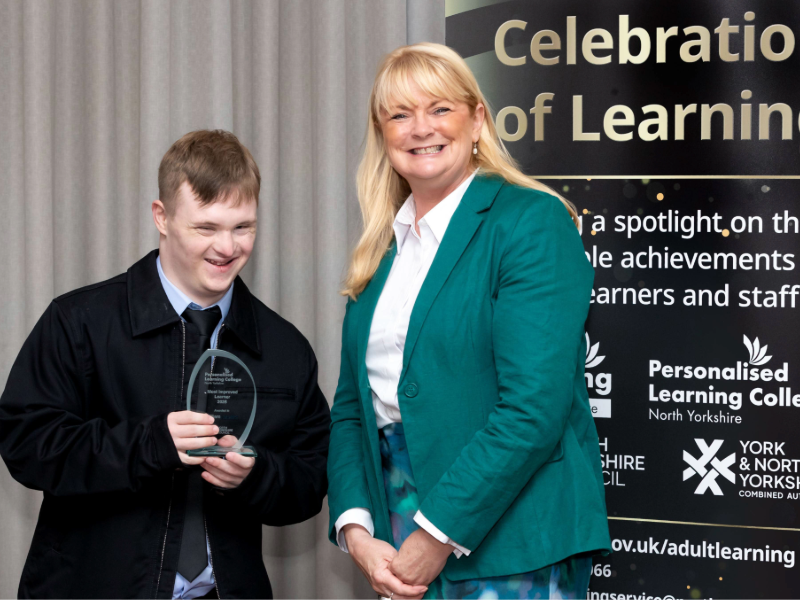 Hope House resident William posing at the awards with a member of the college team on stage