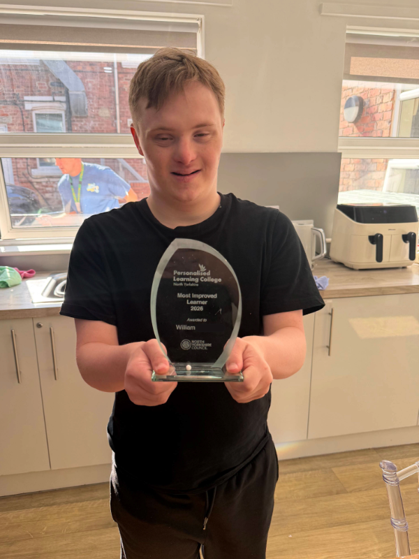 William posing with the glass award at Hope House